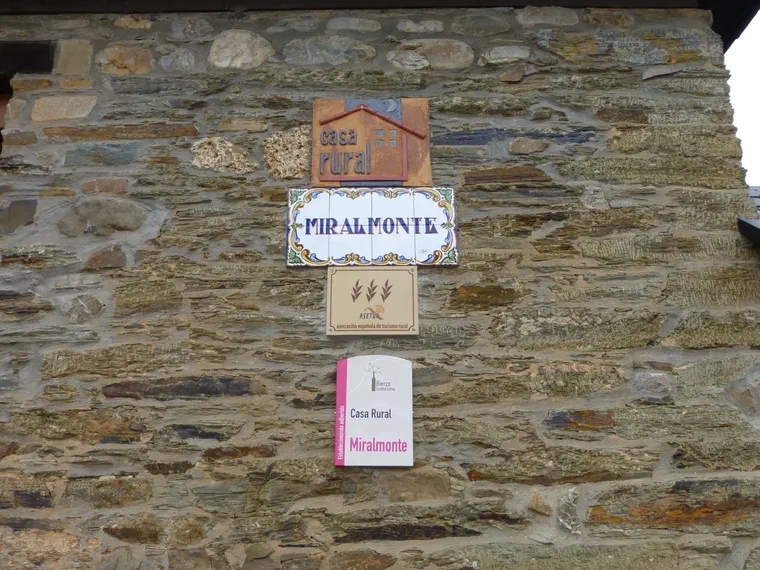 Cartel de cerámica «Miralmonte» en la pared de piedra
