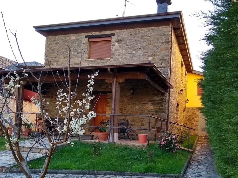 Fachada de la casa con un cerezo en flor en el jardín